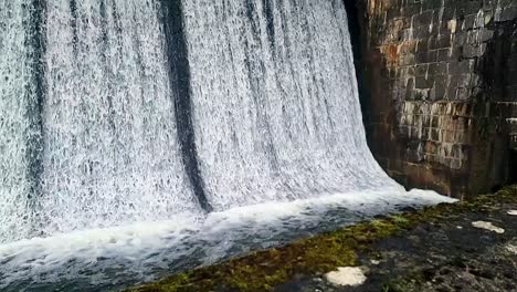 Cefni-concrete-dam-barrier-gate-slow-motion-tilt-up-water-pouring-from-reservoir-overflow