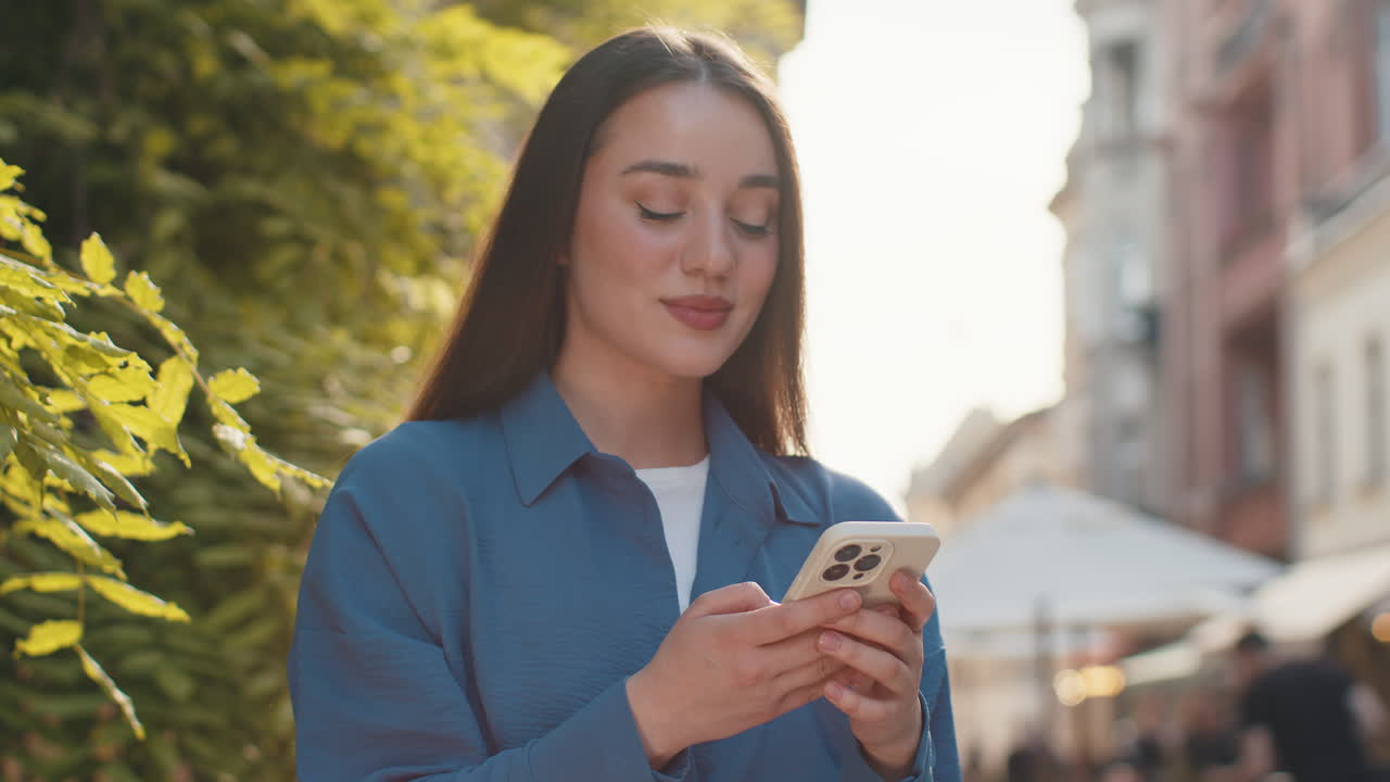 mujer joven usa teléfono inteligente escribiendo mensajes de texto navegando por internet terminando el trabajo mirando a la cámara