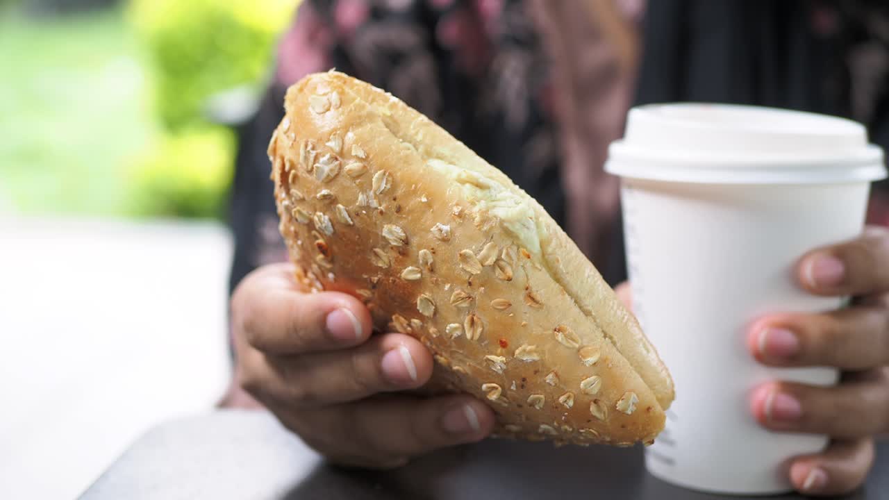 야외에서 오트밀  샌드위치와 커피를 즐기는 사람