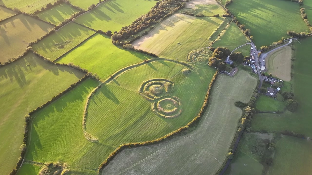 Amazing view of Hill of Tara historical landmark, aerial reveal to Irish landscape, golden light.