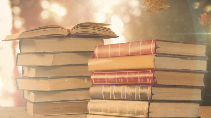 animazione di pila di libri con foglie d'autunno che cadono su luci incandescenti