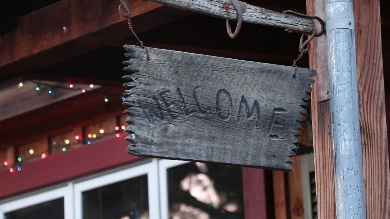 카메라가 나무로 된 환영 표지판을 지나갑니다.