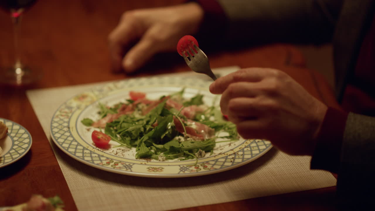 Closeup handsome senior man eating healthy food in restaurant. Romantic dinner