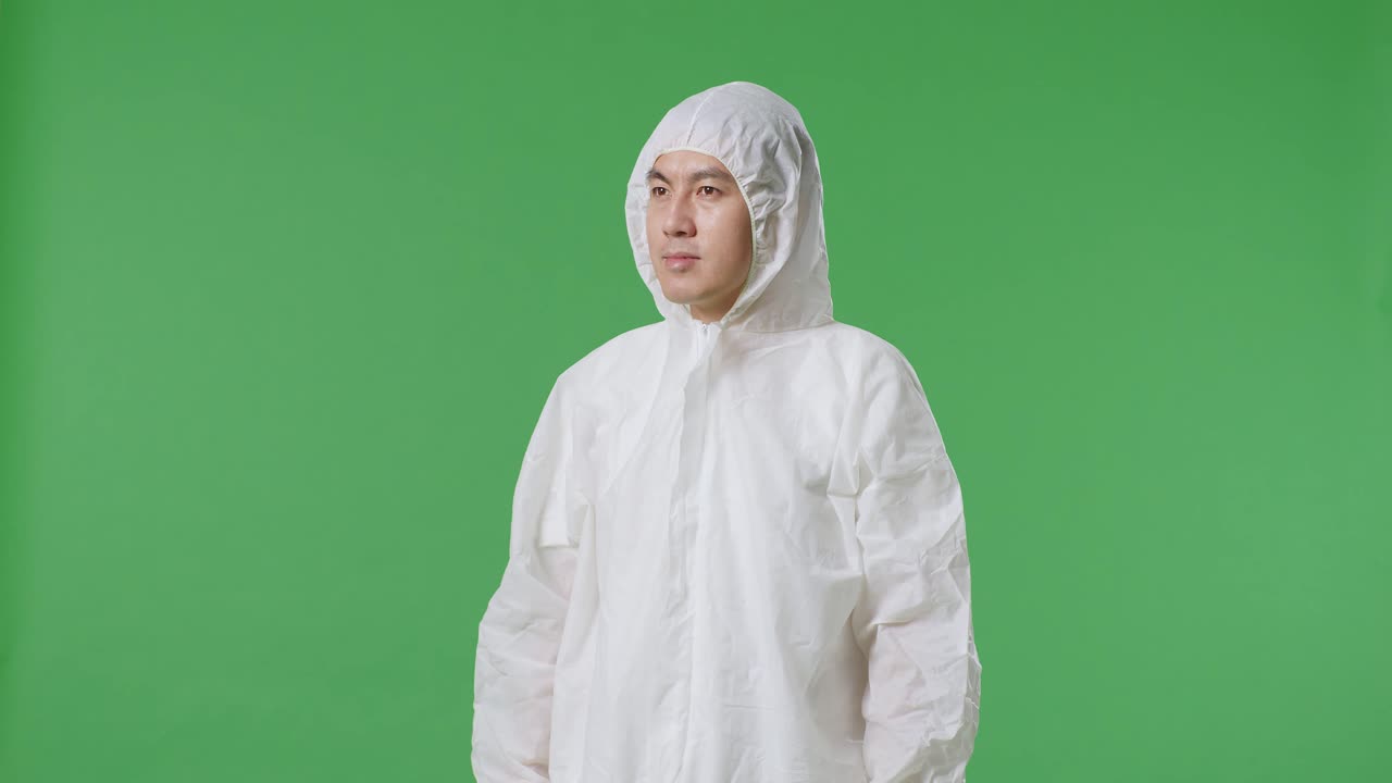 아시아 남성 과학자가 녹색 화면 배경에서 주위를 둘러보고 있습니다.