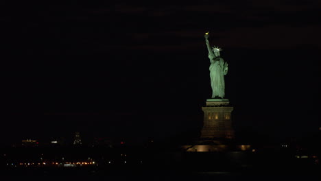 statue of liberty and harbor lights at night