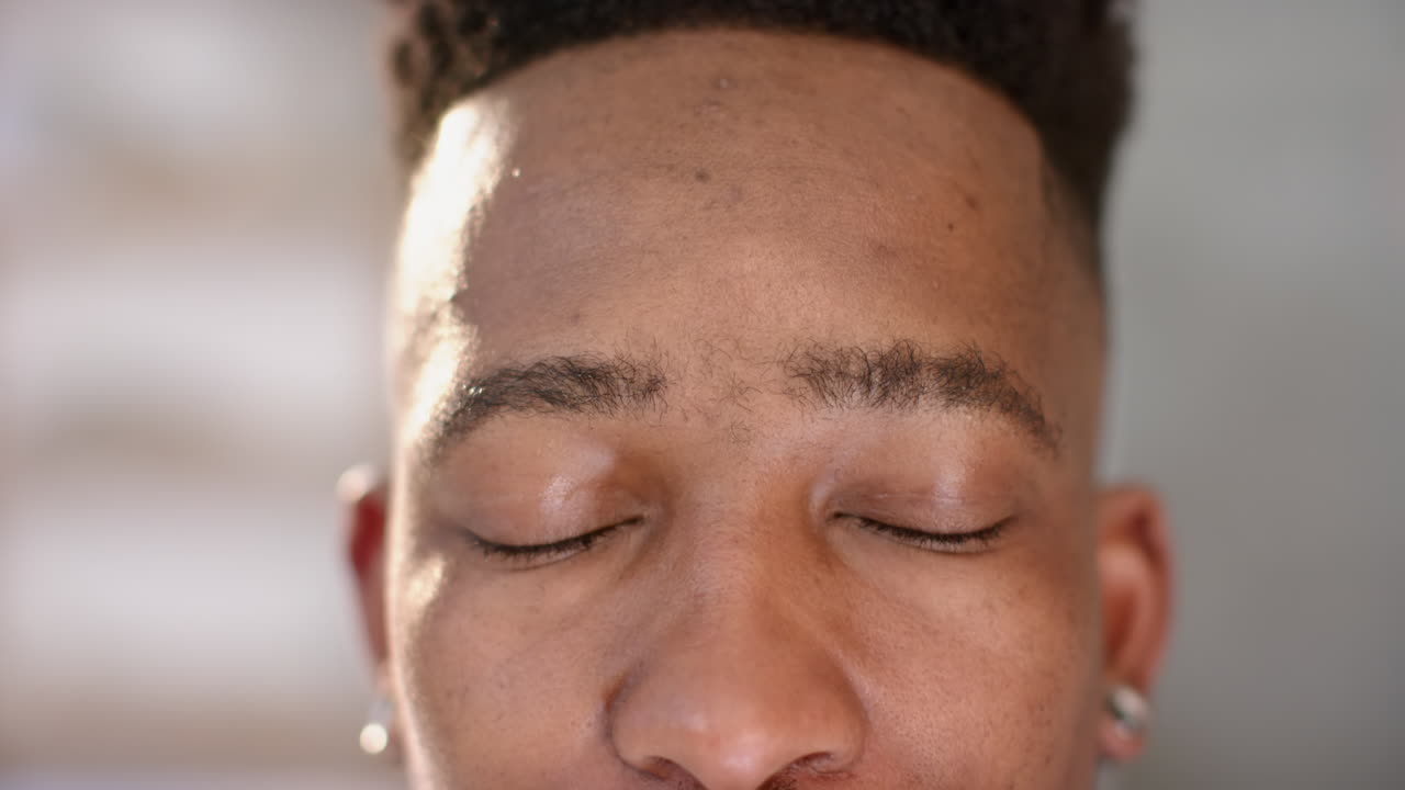 Augen eines glücklichen afroamerikanischen Töpfers blicken in die Kamera in einem Töpferstudio, Zeitlupe