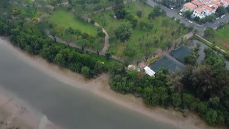 Drone-dolly-tilt-up-reveals-district-2-ho-chi-minh-city-vietnam-on-foggy-day,-establishing