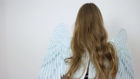 back side of a woman in a dress wearing angel wings