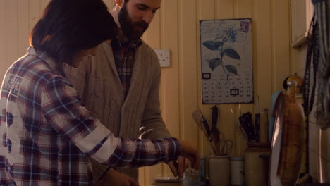 couple cooking food together in kitchen