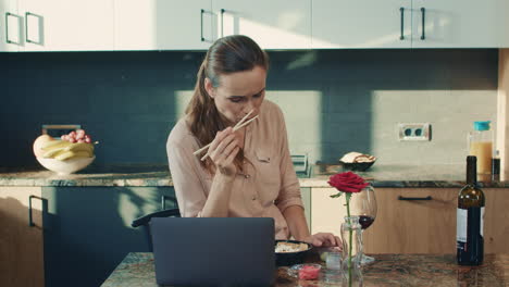 Beautiful-woman-eating-sushi-at-luxury-house.-Upset-woman-watching-laptop.