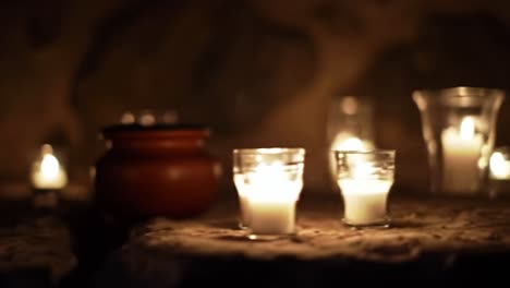 candles illuminate ancient stone in serene underground setting during evening hours