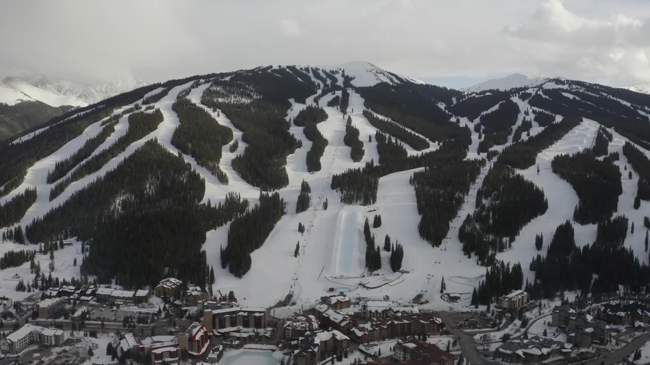 dron aéreo montaña de cobre colorado icono paso épico invierno primavera nublada tarde nevada puesta de sol última luz media tubería silla de elevación esquí corre centro pueblo cinematográfico lentamente hacia adelante hacia abajo movimiento