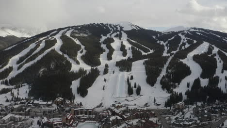 Luftdrohne-Kupfer-Berg-Colorado-Ikone-Epic-Pass-Winter-Frühling-Bewölkt-Verschneit-Nachmittag-Sonnenuntergang-Letztes-Licht-Halfpipe-Sessellift-Skipisten-Zentrum-Dorf-Filmisch-Langsam-Vorwärts-Abwärtsbewegung