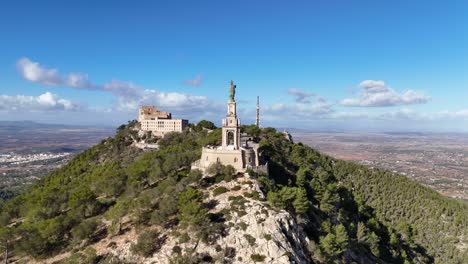 vuelo en órbita aérea alrededor de la famosa estatua de san salvador en la cima de la montaña durante un día soleado en la isla de mallorca