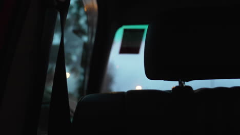 passenger-on-back-seat-view-of-city-car-driving-during-rush-hours-at-evening