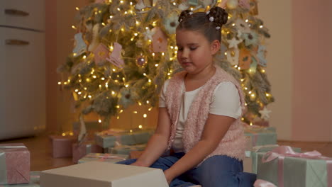 little girl opens gift box, golden light comes out, she is surprised