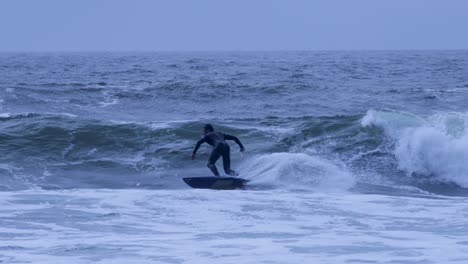 joven atleta surfista montando algunas olas en carcavelos con línea y estilo