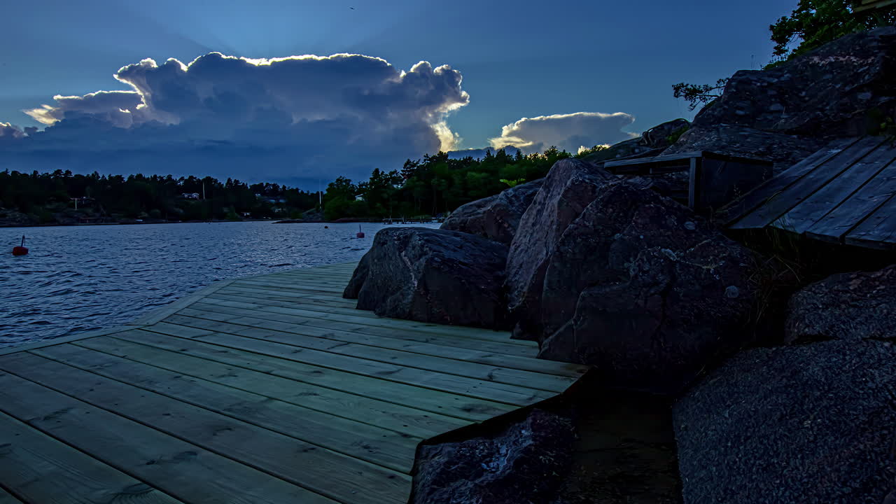 atardecer sobre un lago con siluetas de árboles oscuros en la distancia
