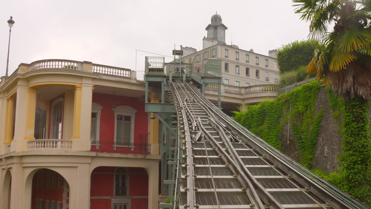 The historic Pau Funicular railway ascending its steep track, set against a backdrop of lush green foliage and classic French architecture in Pau, Nouvelle-Aquitaine, France