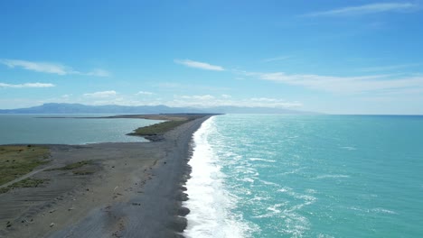 aerial approach towards lake ellesmere above beautiful turquoise-colored south pacific ocean