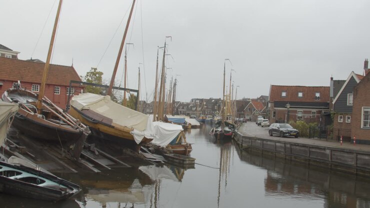 Vecchia barca botter olandese in un bacino di manutenzione in un canale che attraversa un piccolo villaggio di pescatori nei Paesi Bassi.