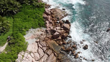 vista aérea de las olas rompiendo en la costa despoblada de anse songe en la digue, una isla de las seychelles