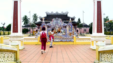 women stand next to a buddhist temple and talk