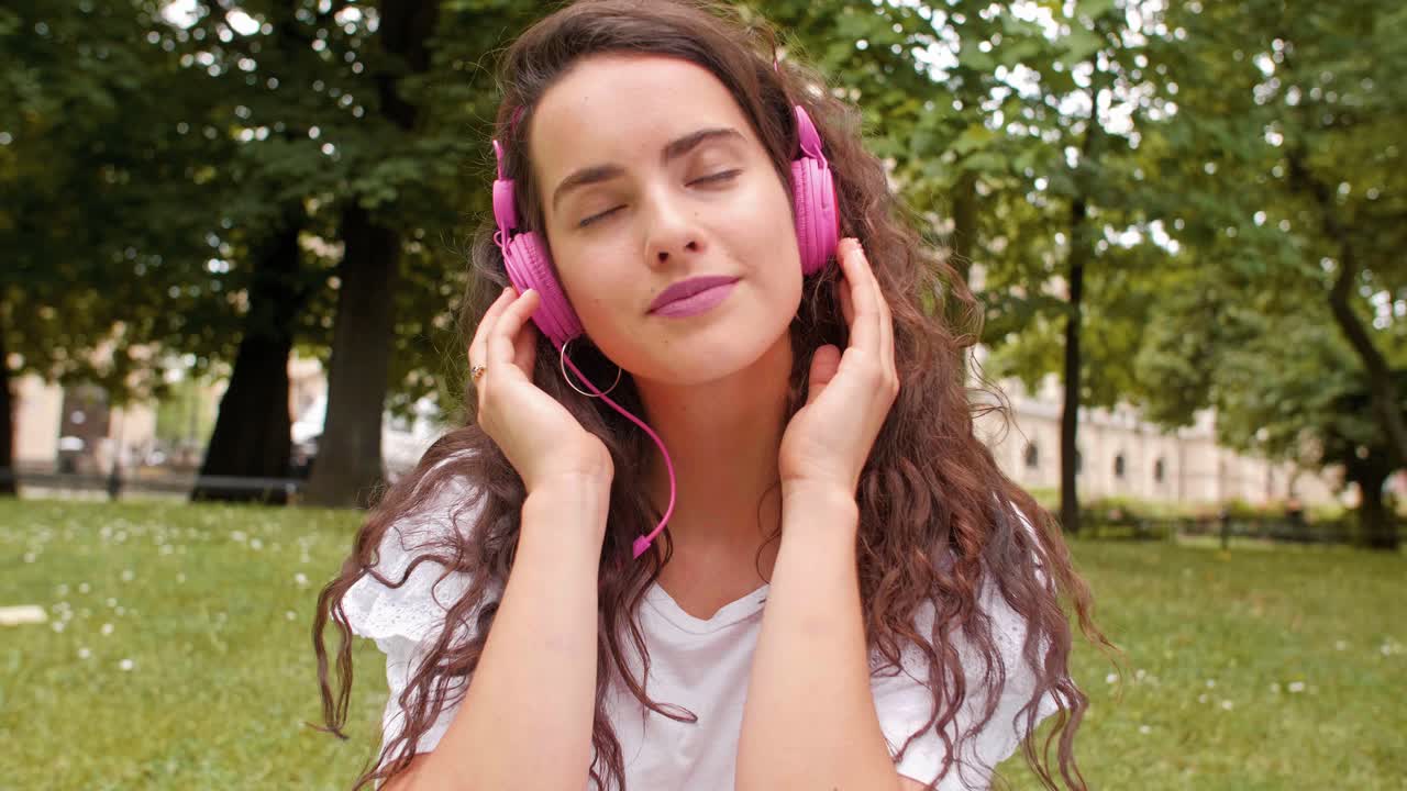 una mujer joven escuchando música con auriculares.