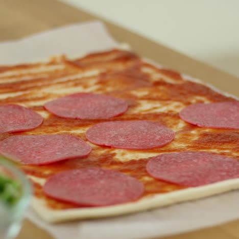 Woman-making-a-homemade-salami-and-mushroom-pizza