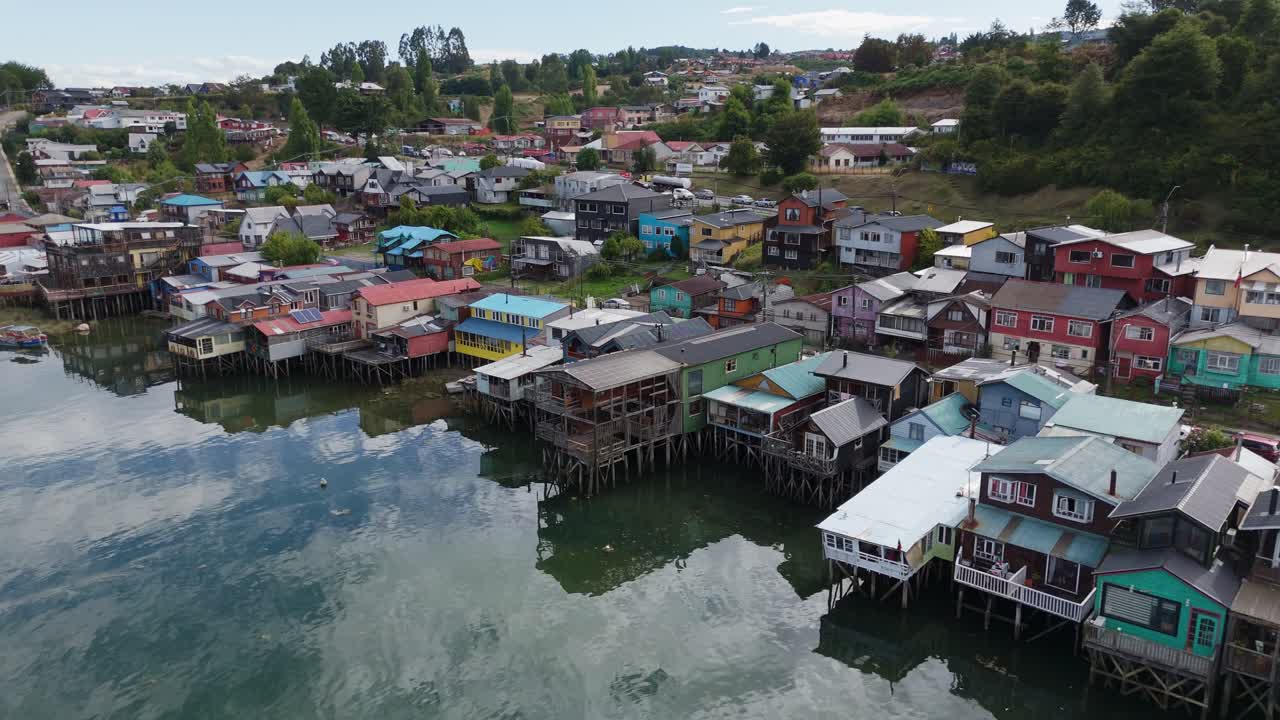 Aerial view of palafitos, traditional colorful wooden stilt houses, reflecting on the water in Castro, Chiloe Island, Chile. circle dolly