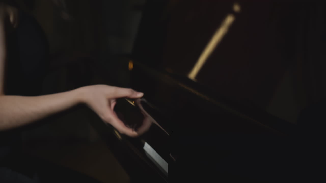 mujer tocando el piano en una habitación oscura