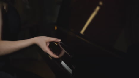 woman playing piano in dark room