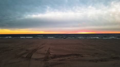 rising over the sandy beaches of michigan during a fall sunset