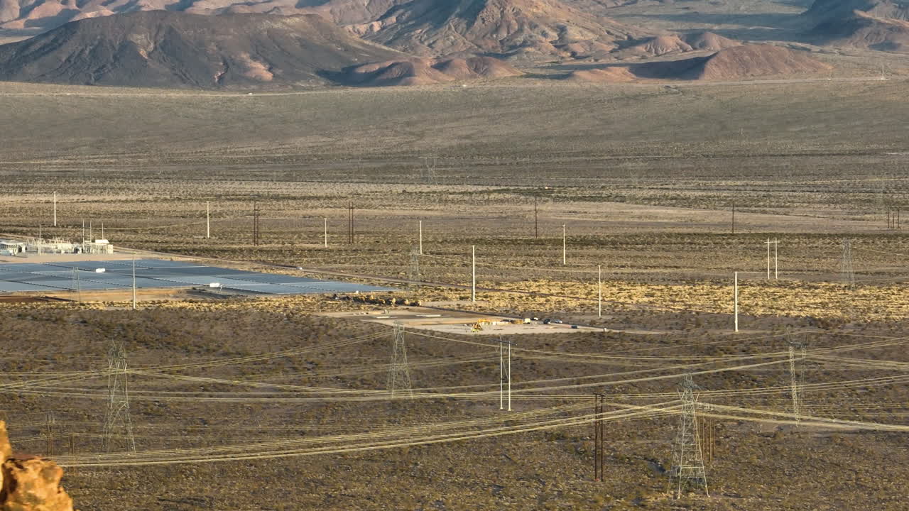 granja solar que revela detrás de una montaña del desierto de nevada, aérea