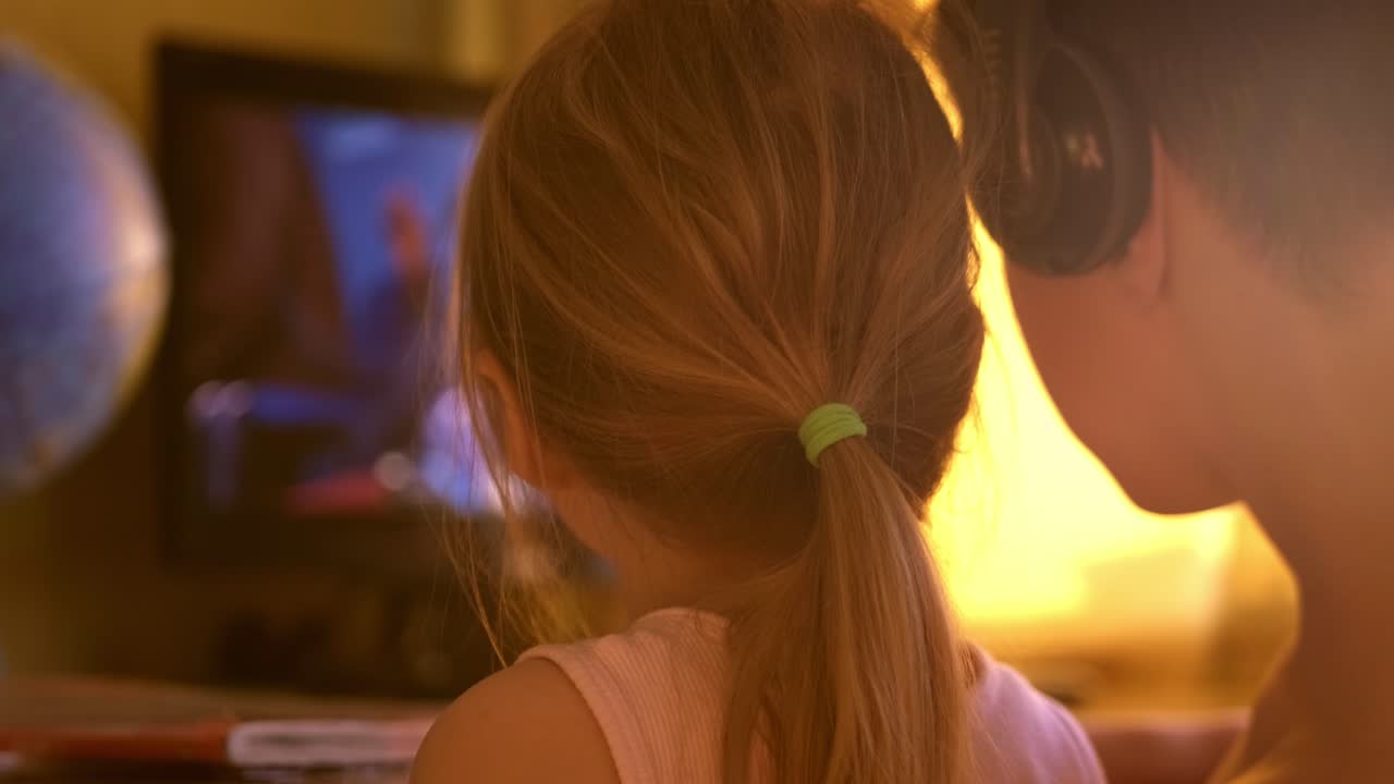 Captivated by Imagery: Two Children Engaged in Screen Time Together, Sharing Moments while Watching Their Favorite Show with a Warm Glow
