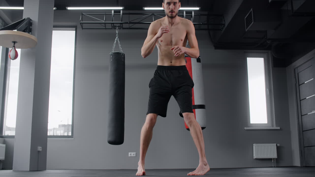 Man Practicing Muay Thai Kicks in Gym