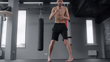 man practicing muay thai kicks in gym