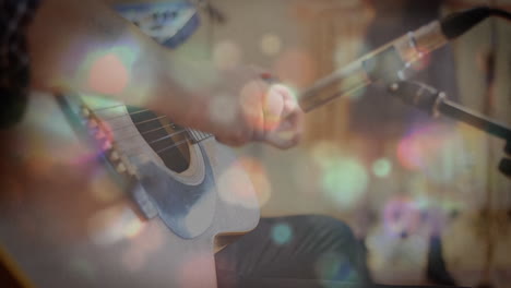 glowing spots of lights against man playing guitar