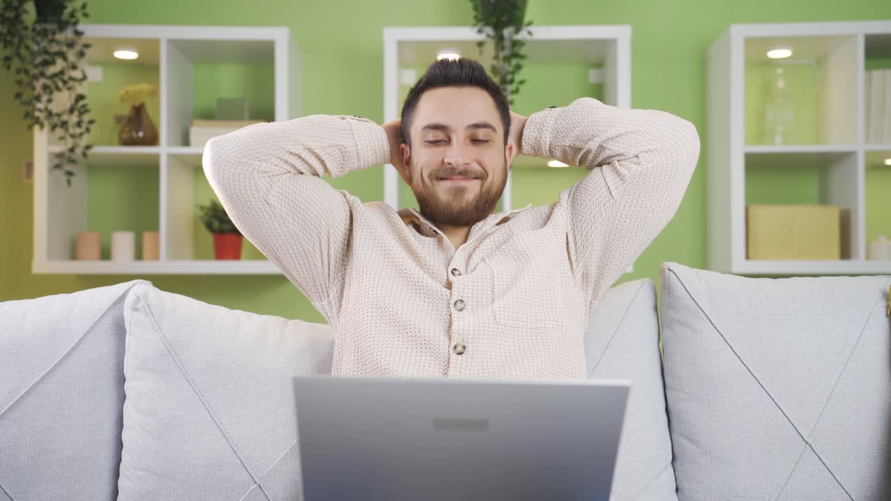 Happy young man shopping online at home.