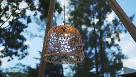 Una-Lámpara-De-Mimbre-Encendida-Que-Cuelga-De-La-Decoración-De-Una-Boda-Nocturna-En-El-Exterior.