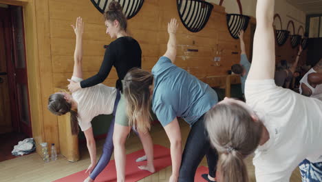yoga class practicing triangle pose