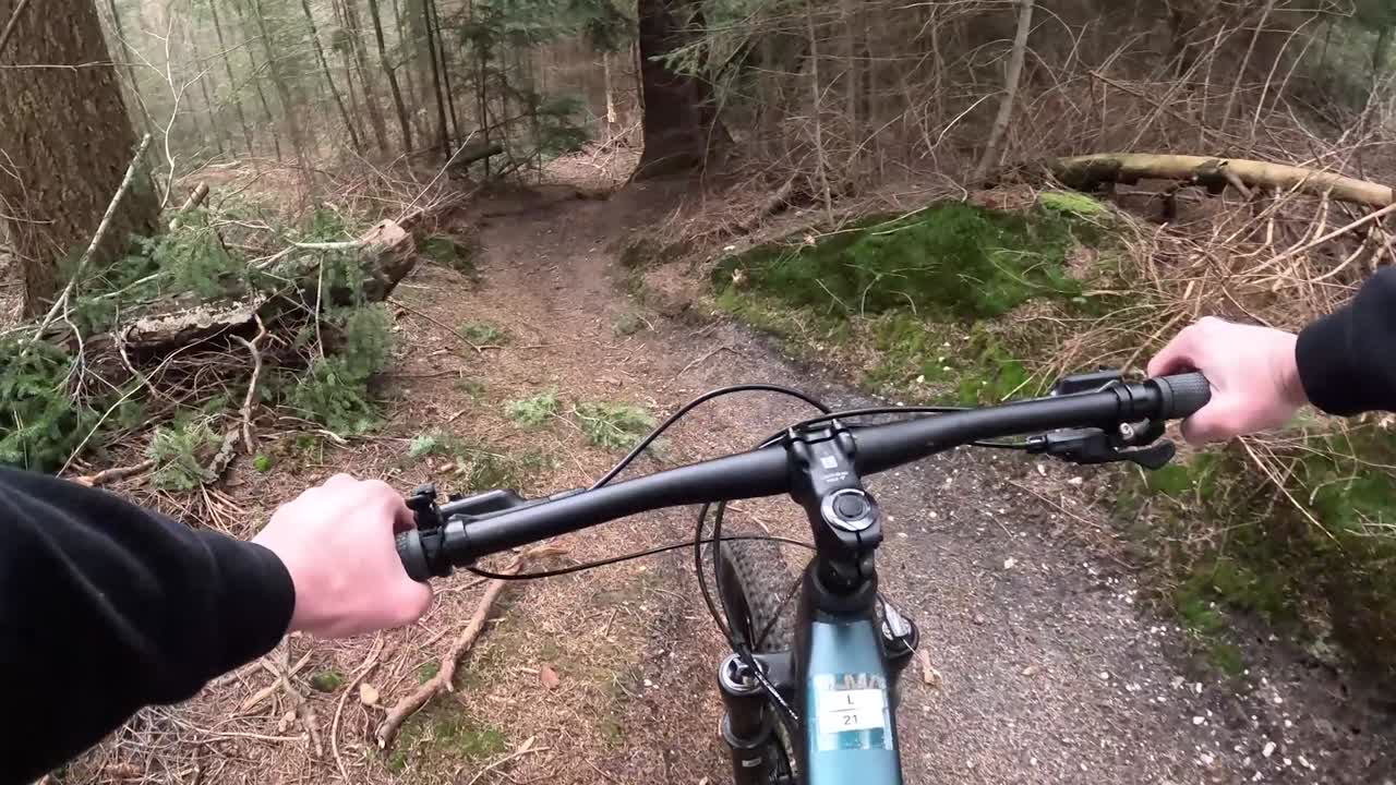 Video som visar mountainbikecykling genom tät skog.