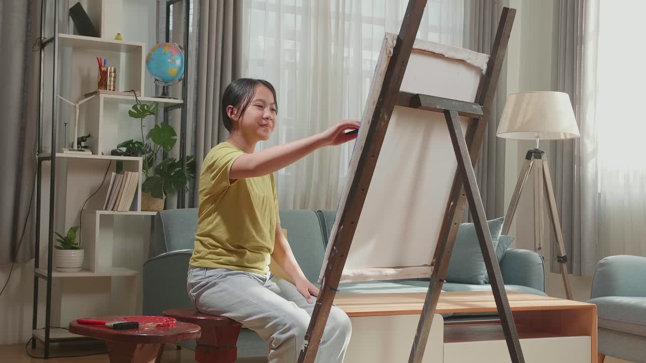 Asian Artist Girl Holding Paintbrush And Painting On The Canvas