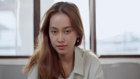 approaching slow-motion shot of a woman as she begins to smile at the camera.