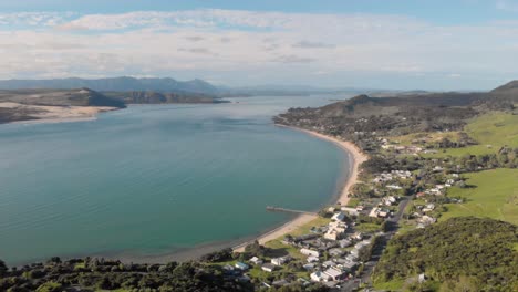Drone-view-flying-lower-towards-Omapere,-New-Zealand