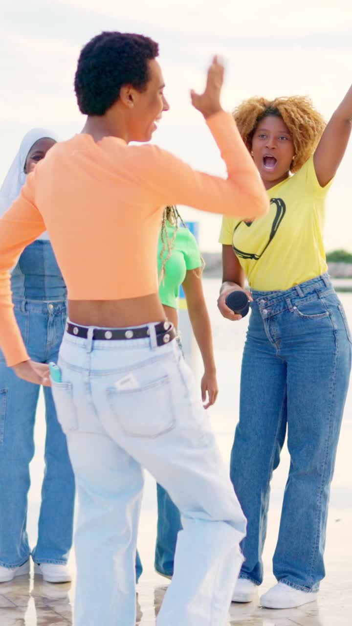 Multi-ethnic friends turning to dance freestyle next to the sea