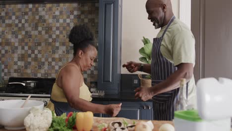 happy senior african american couple dancing in ktichen in slow motion