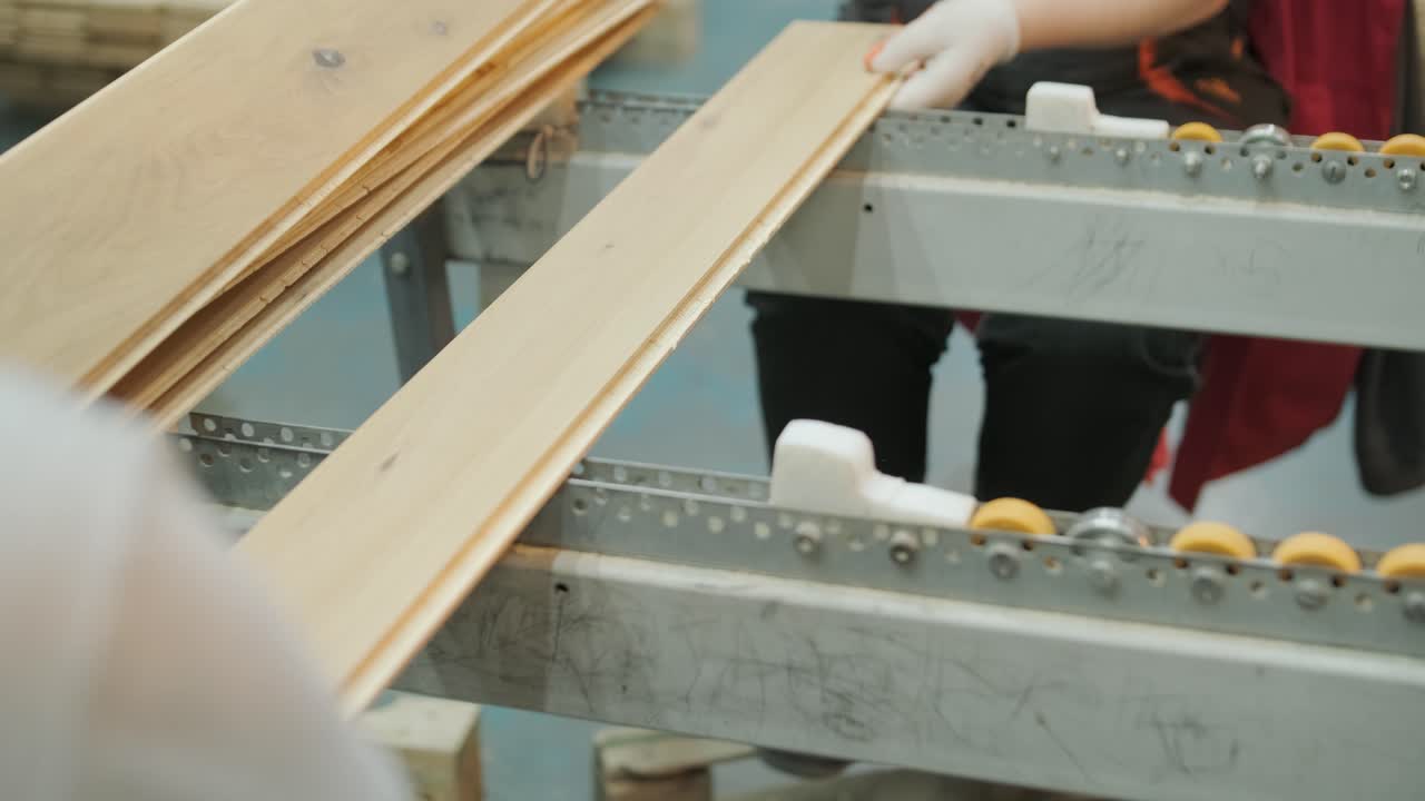 工廠內輸送帶上的木板由工人堆疊