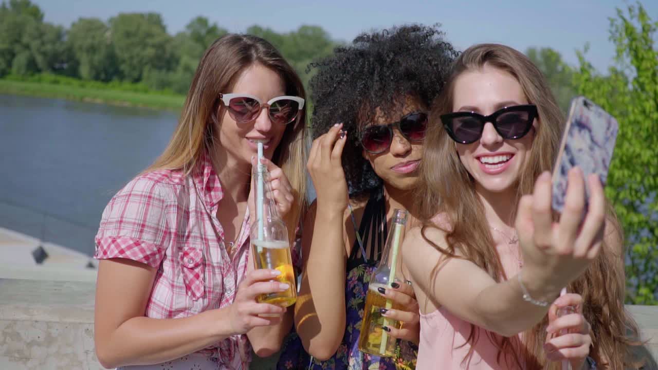 mujeres tomando selfie con cerveza