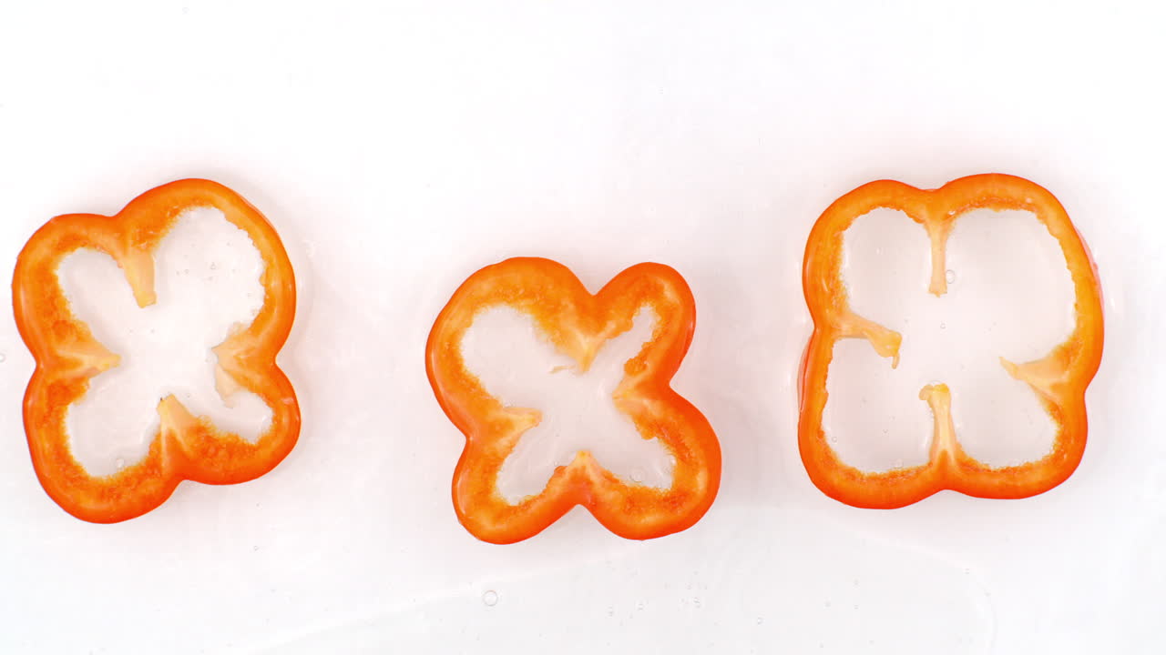 느린 동작에서 물 스프레이는 색 배경에 많은 고추와 맛있는 야채에 물을 습니다. 채식주의자 및 과일주의자.